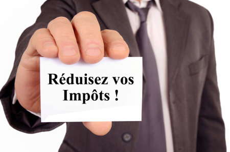 Businessman showing a card that says in french reduce your taxesの写真素材