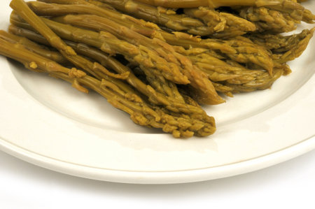 Green asparagus in a plate close-up on white backgroundの写真素材