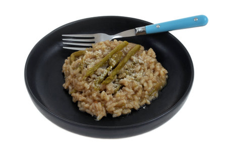Plate of homemade green asparagus risotto with a fork close-up isolated on white backgroundの写真素材