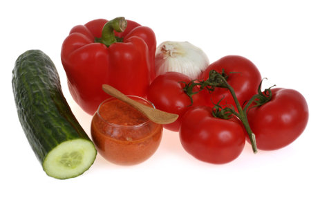 Homemade gazpacho glass with wooden spoon and ingredients close-up isolated on white backgroundの写真素材