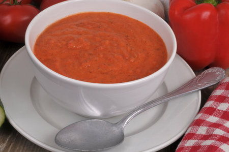 Bowl of homemade gazpacho with a spoon closeup on backgroundの写真素材