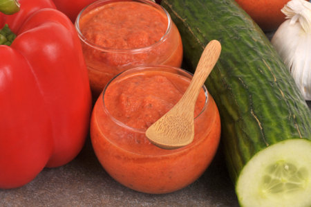 Homemade gazpacho glasses with ingredients and a wooden spoon closeup top viewの写真素材