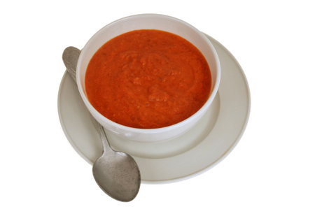 Bowl of homemade gazpacho with spoon close-up isolated on white background viewed from aboveの写真素材