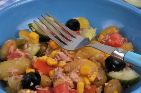 Homemade mixed salad served on a plate with a fork closeup on backgroundの写真素材