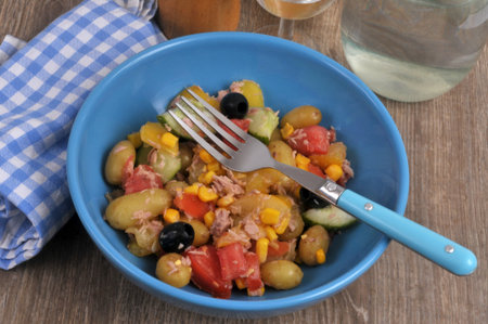 Homemade mixed salad served on a plate with a fork, top view closeupの写真素材