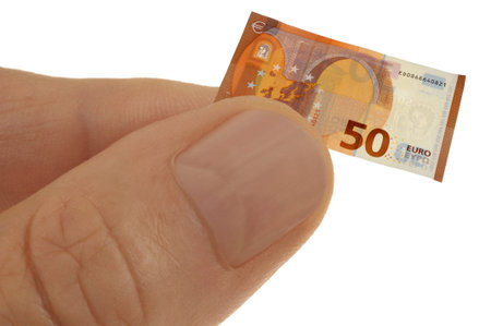 Budget restriction concept with a hand holding a miniature fifty euro banknote close-up isolated on...