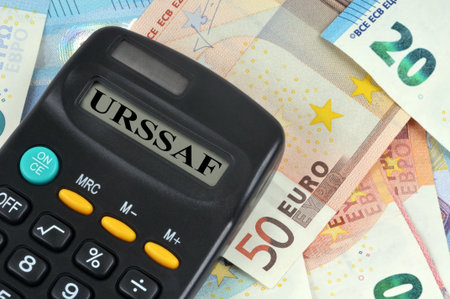 URSSAF tax collection concept with a close-up of a calculator and a background of euro banknotesの写真素材
