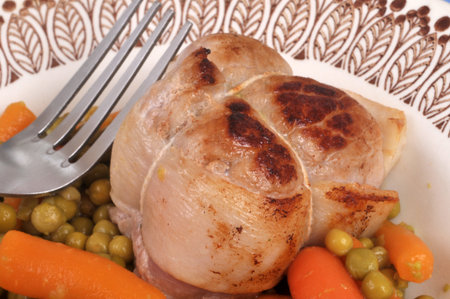 Veal paupiette with peas and carrots on a plate with a fork in closeupの写真素材