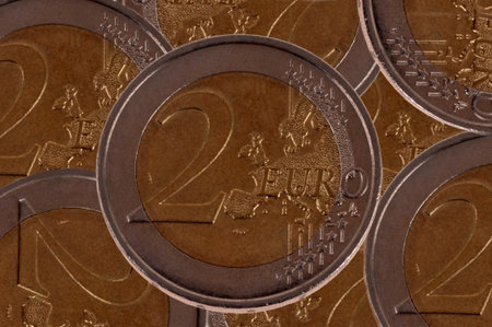 Close-up of a two euro coin against a background of other two euro coins
