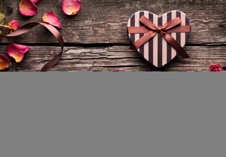 Gift box in the shape of a heart on a wooden backgroundの写真素材