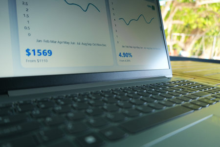 A laptop screen displays financial data, including two graphs and key statistics such as $1569 and 4.90%, indicating a workspace for analyzing financial trends and performance.の写真素材