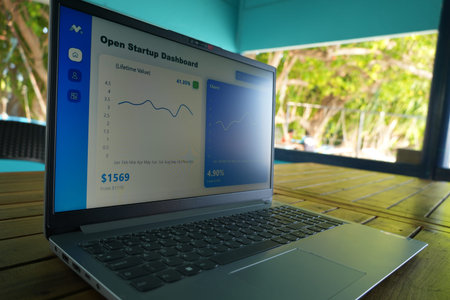A laptop shows an Open Startup Dashboard with graphs and statistics on its screen, placed on a...