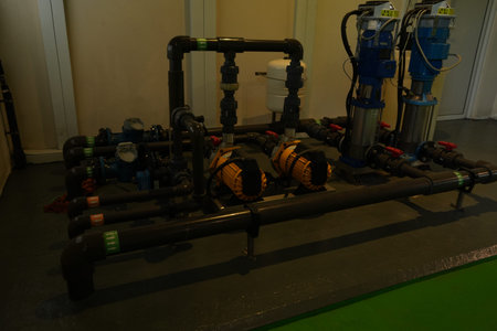 An intricate network of industrial pipes and pumps creates a complex fluid system.