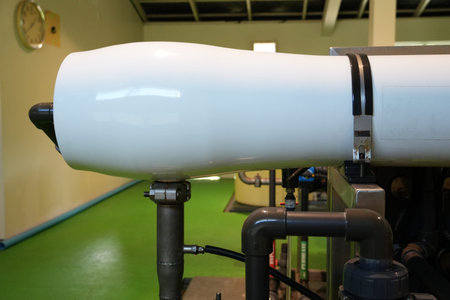 A large white cylindrical reverse osmosis membrane housing stands in an industrial treatment plant.の写真素材