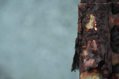Deep rust and weathered paint on old metal pipes creating an abstract texture.