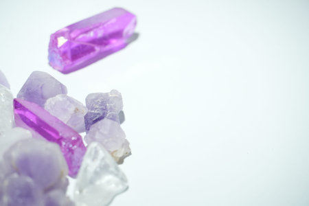 Various natural and treated purple crystals arranged on a clean white surface with copy space.