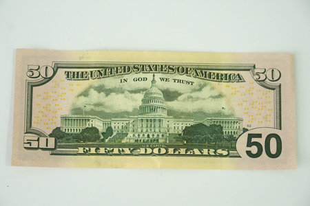 The reverse side of a United States fifty dollar bill featuring the iconic US Capitol Building.