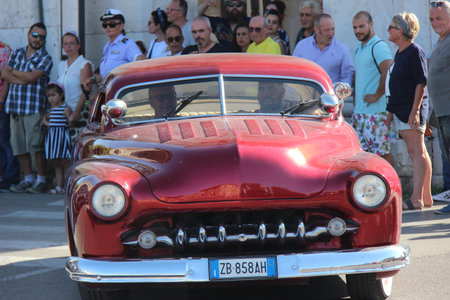 People vintage, Senigallia, Italy 12 August 2019 is an international music festival focused on American music and culture of the 1950s. In the photo: parade of vintage cars and people dressed in vintaのeditorial素材