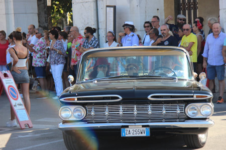 People vintage, Senigallia, Italy 12 August 2019 is an international music festival focused on American music and culture of the 1950s. In the photo: parade of vintage cars and people dressed in vintaのeditorial素材