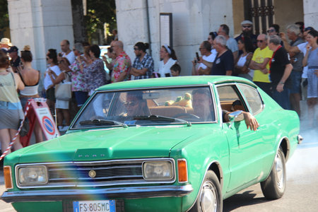 People vintage, Senigallia, Italy 12 August 2019 is an international music festival focused on American music and culture of the 1950s. In the photo: parade of vintage cars and people dressed in vintaのeditorial素材