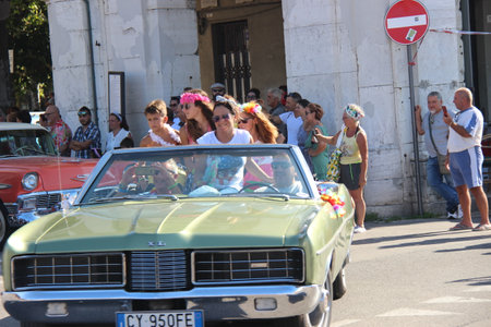 People vintage, Senigallia, Italy 12 August 2019 is an international music festival focused on American music and culture of the 1950s. In the photo: parade of vintage cars and people dressed in vintaのeditorial素材