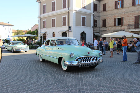 People vintage, Senigallia, Italy 12 August 2019 is an international music festival focused on American music and culture of the 1950s. In the photo: parade of vintage cars and people dressed in vintaのeditorial素材