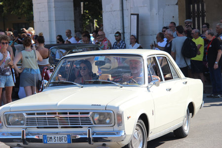People vintage, Senigallia, Italy 12 August 2019 is an international music festival focused on American music and culture of the 1950s. In the photo: parade of vintage cars and people dressed in vintaのeditorial素材