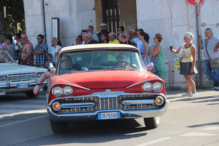 People vintage, Senigallia, Italy 12 August 2019 is an international music festival focused on American music and culture of the 1950s. In the photo: parade of vintage cars and people dressed in vintaのeditorial素材