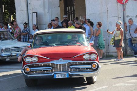 People vintage, Senigallia, Italy 12 August 2019 is an international music festival focused on American music and culture of the 1950s. In the photo: parade of vintage cars and people dressed in vintaのeditorial素材