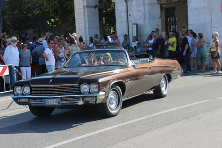 People vintage, Senigallia, Italy 12 August 2019 is an international music festival focused on American music and culture of the 1950s. In the photo: parade of vintage cars and people dressed in vintaのeditorial素材