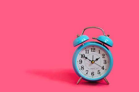 Retro classical blue clock on pink background