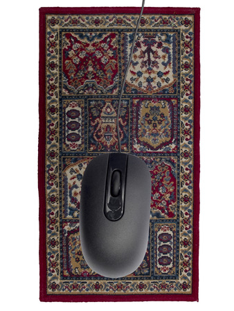 Black computer mouse on the carpet with traditional ornamentの写真素材