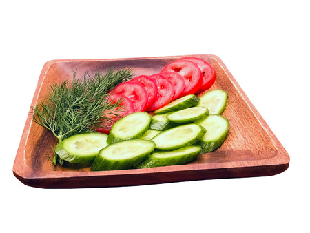 Fresh raw vegetable salad with tomatoes, cucumbers and fennel on wooden plate. Isolated on white background.の写真素材