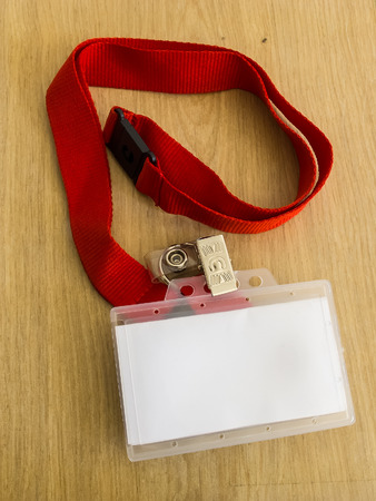 Identity card with red strap on wooden tableの写真素材