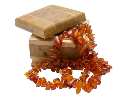Wooden box with amber necklace isolated on white backgroundの写真素材