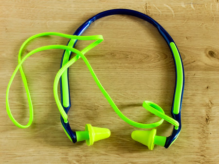 Set of blue and green ear plugs on wooden background