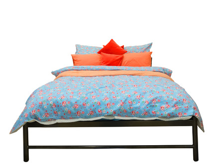 Bed with colorful duvet and cushions isolated on white backgroundの写真素材