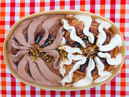 Chocolate ice cream in box on a table with checkered cloth. Top view