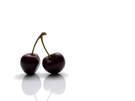 Pair of fresh sweet cherries isolated on white backgroundの写真素材