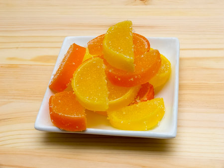 Color fruit jelly candies on a plate on a wooden background