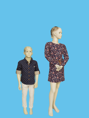 Two mannequins dressed in fashionable kids wear.  Isolated on blue background. No brand names or copyright objects.の写真素材