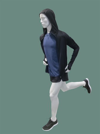 Running male mannequin isolated on green background. No brand names or copyright objects.の写真素材