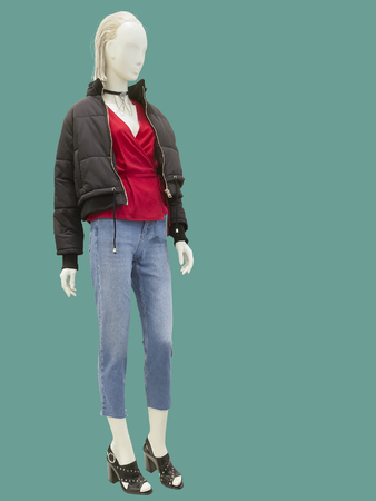 Full-length female mannequin dressed in fashionable clothes, isolated on green background. No brand names or copyright objects.の写真素材