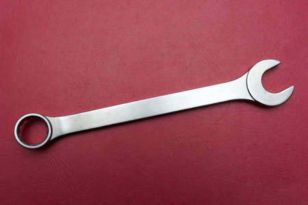 Single chrome vanadium spanner over red background.の写真素材
