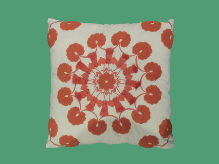 Decorative pillow with a pattern of red threads embroidered. Isolated on green background.の写真素材