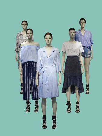 Group of female mannequins wear fashionable summer clothes, isolated on green background. No brand names or copyright objects.の写真素材