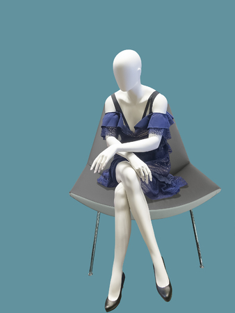 Sitting female mannequin wearing blue dress, isolated.  No brand names or copyright objects.の写真素材