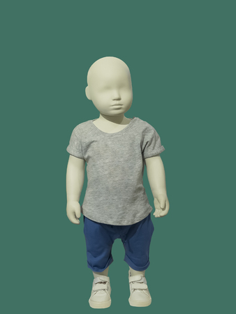 Full-length child mannequin dressed in casual clothes, isolated on green background. No brand names or copyright objects.の写真素材