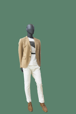 Full-length male mannequin dressed fashionable clothes, isolated on green background. No brand names or copyright objects.の写真素材