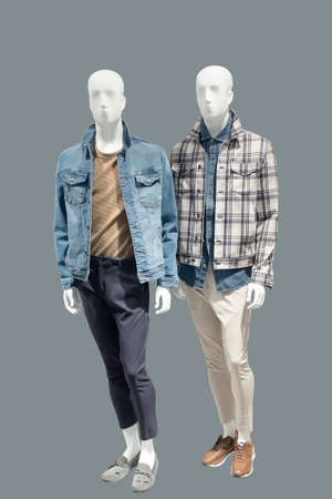 Two full-length male mannequins dressed in casual clothes, isolated on gray background. No brand names or copyright objects.の写真素材
